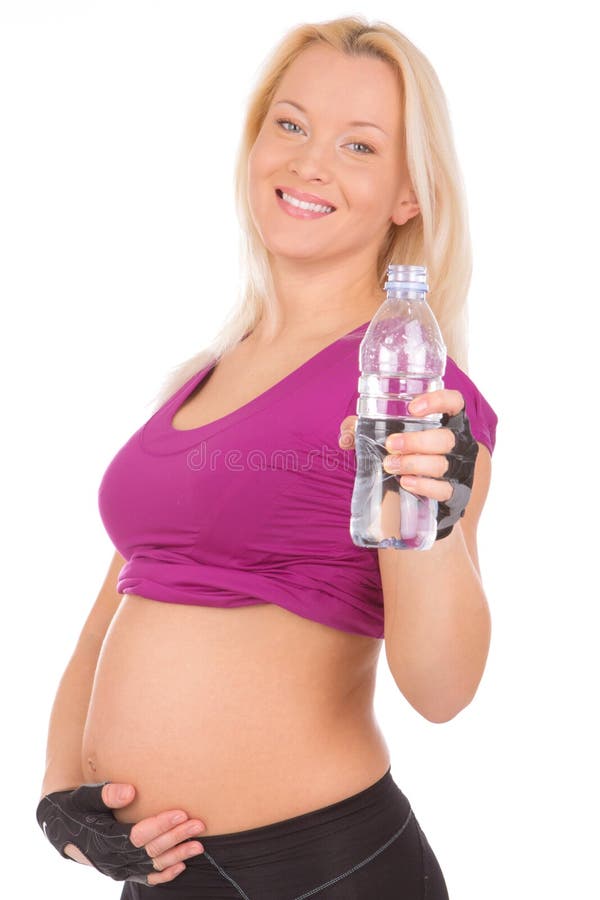 Young woman drinking water after fitness exercise