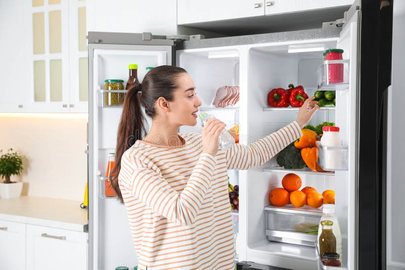 Woman Drinking Water Near Open Refrigerator in Kitchen Stock Image ...