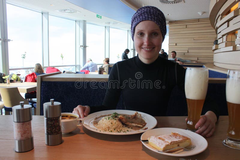 Young woman eating in Alpine restaurant.