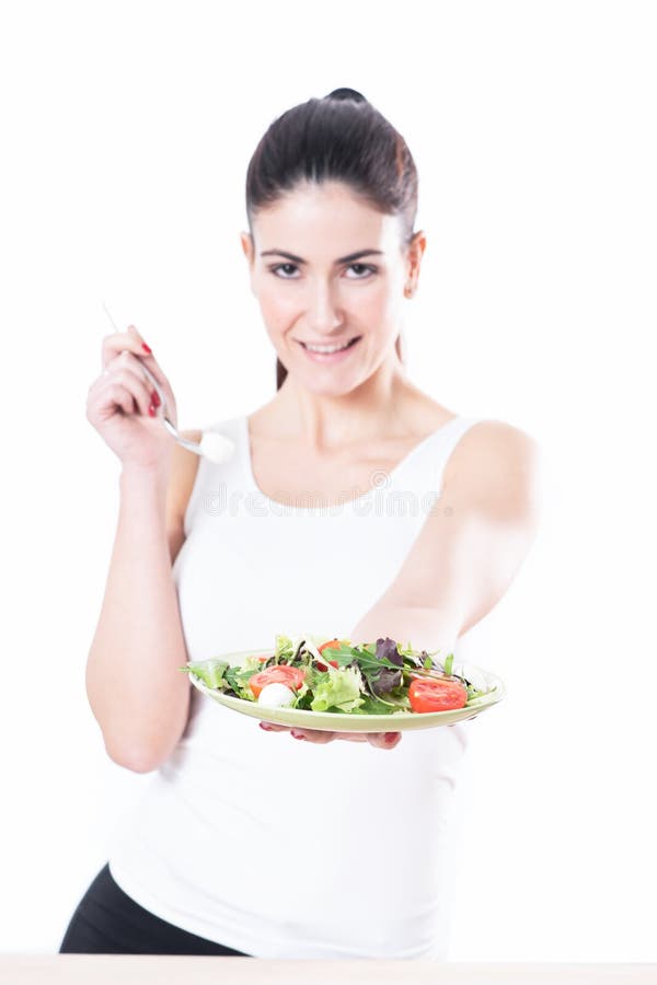 Young woman eating a bowl of healthy organic salad royalty free stock image