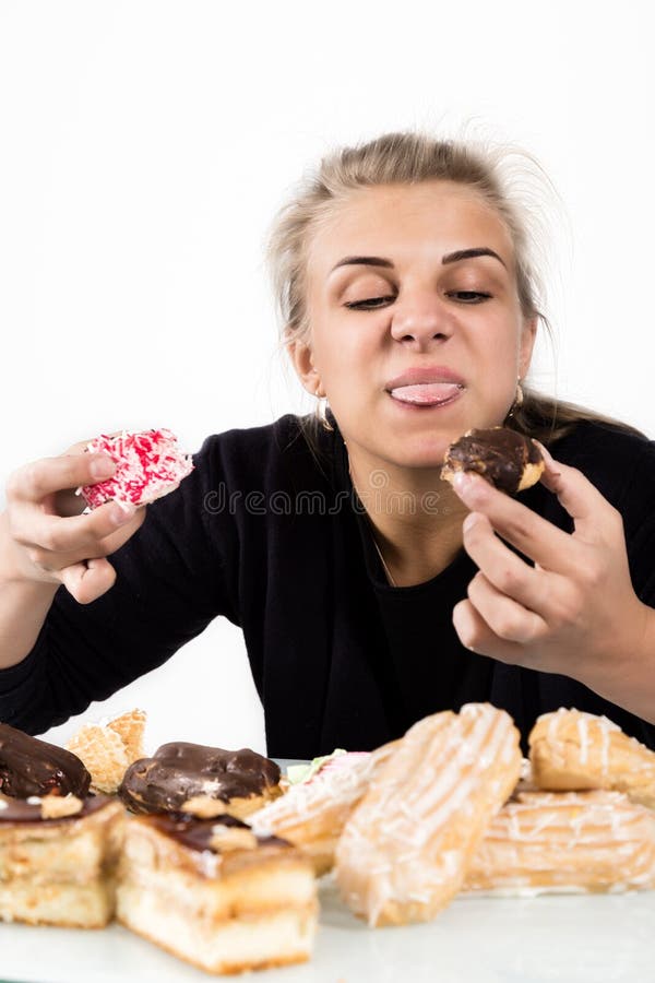 Young Woman Eating Cupcakes with Pleasure after a Diet Stock Photo