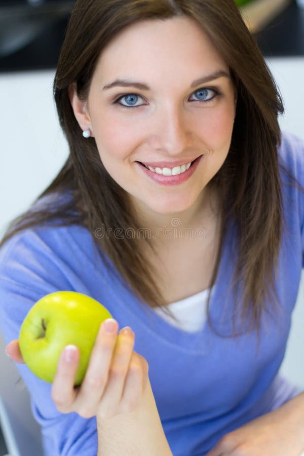 Young woman eating green apple. stock photography