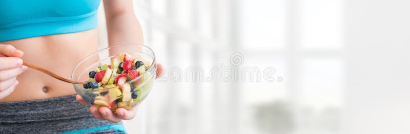 Young woman eating a healthy fruit salad after workout. stock images Young woman eating a healthy fruit salad after workout. stock images