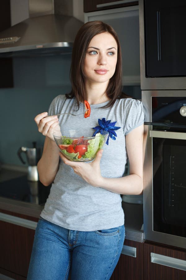 Young woman is eating salad royalty free stock images