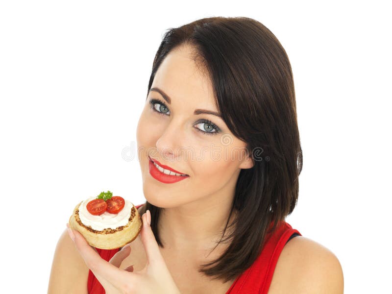 Young Woman Eating Toasted Crumpet with Cream Cheese and Tomato