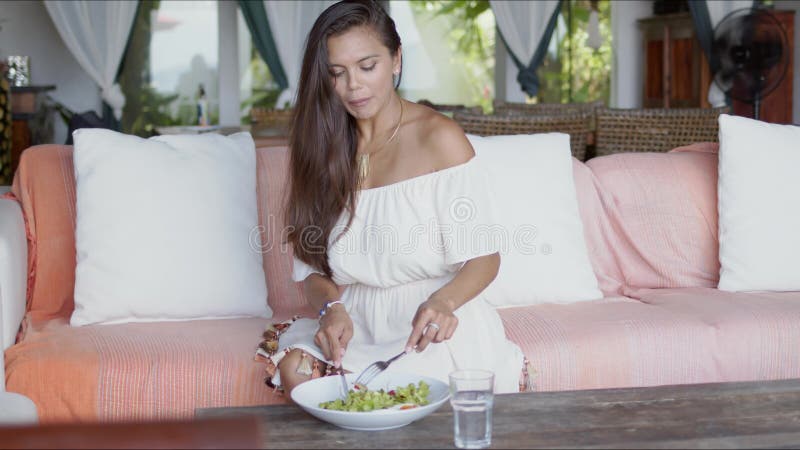 Young woman enjoying lunch at home sofa