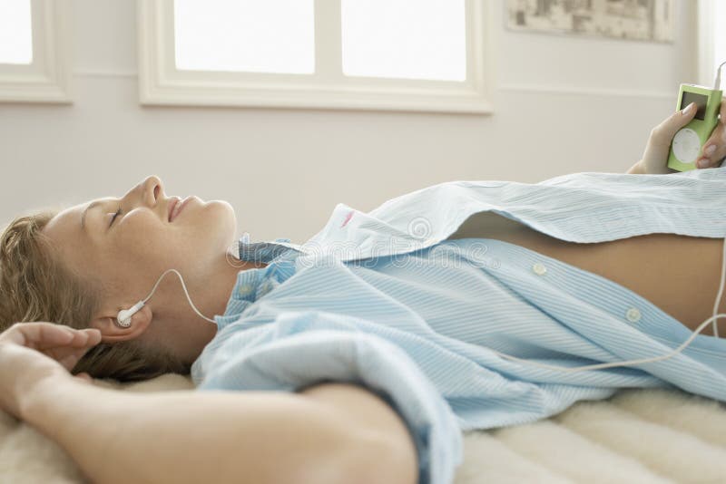 Young Woman Enjoying Music Through Mp3 Player