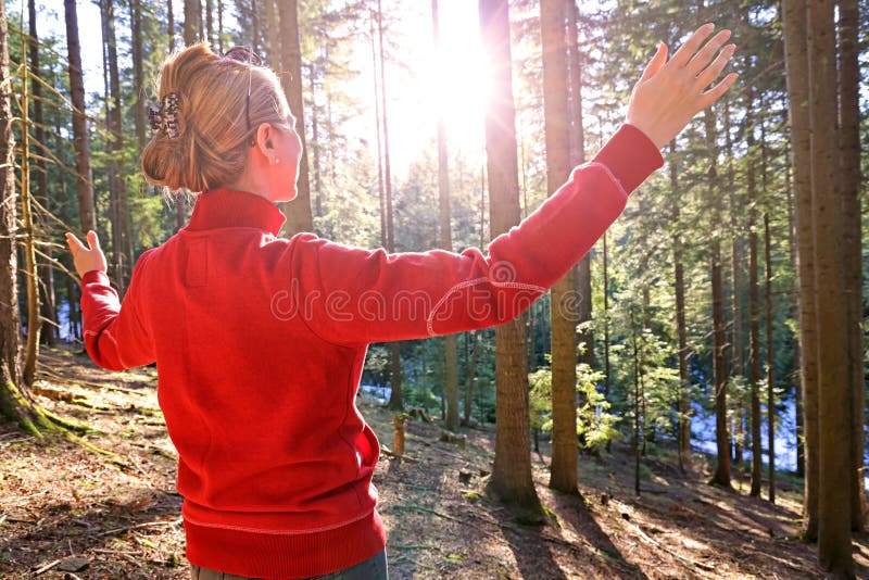 Young woman enjoys at beautiful sunset in pine forest mountain