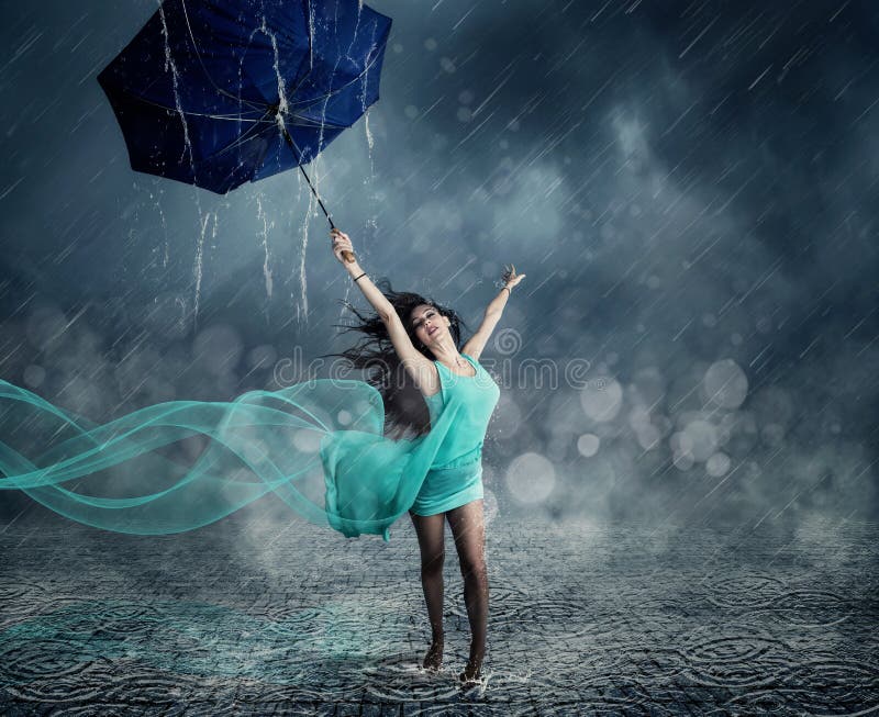 Young woman in evening dress dancing in the rain