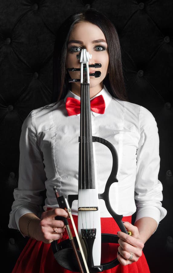 Young woman face with a violin stock photo Young woman face with a violin stock photo