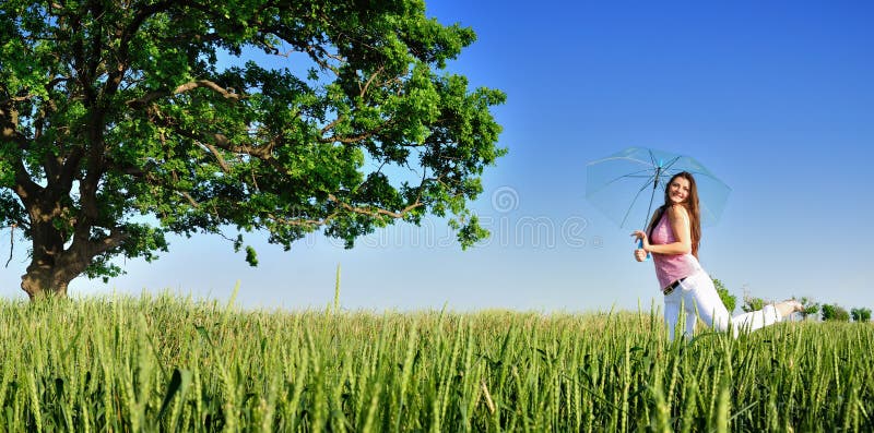 Young woman in a field with umbrella panoramic