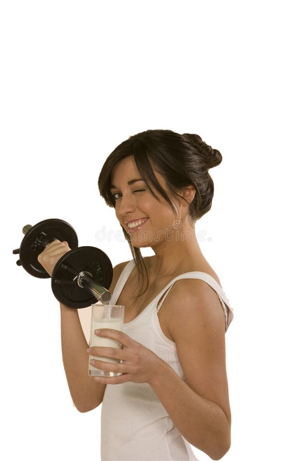 Young woman wrinking the eyewith a weight in an hand and a glass of milk in the other to give the idae that milk wil give you strenght. Weight watchers stock images, royalty-free photos and pictures