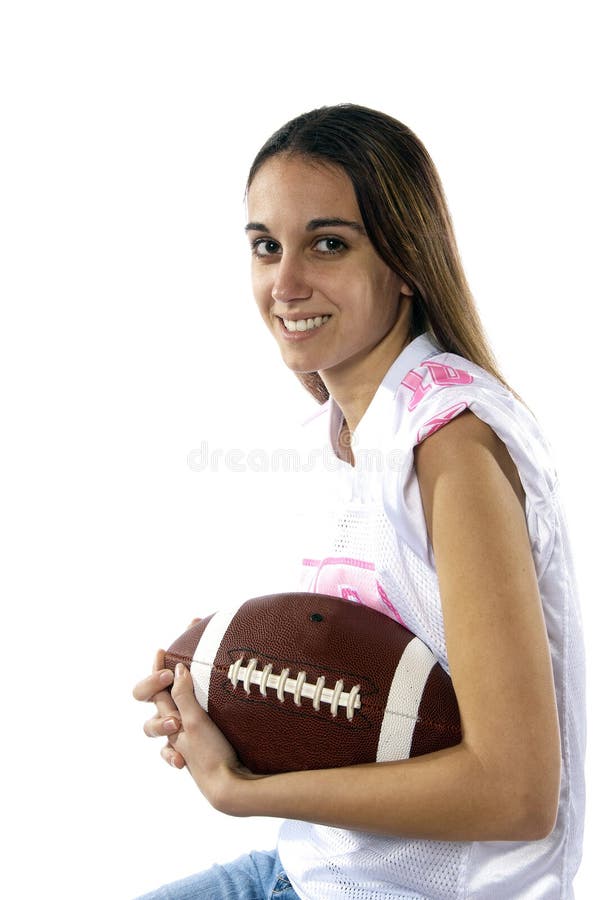 Young woman wearing football jersey and has a football. She is ready for the game to begin. Young woman wearing football jersey and has a football. She is ready for the game to begin.