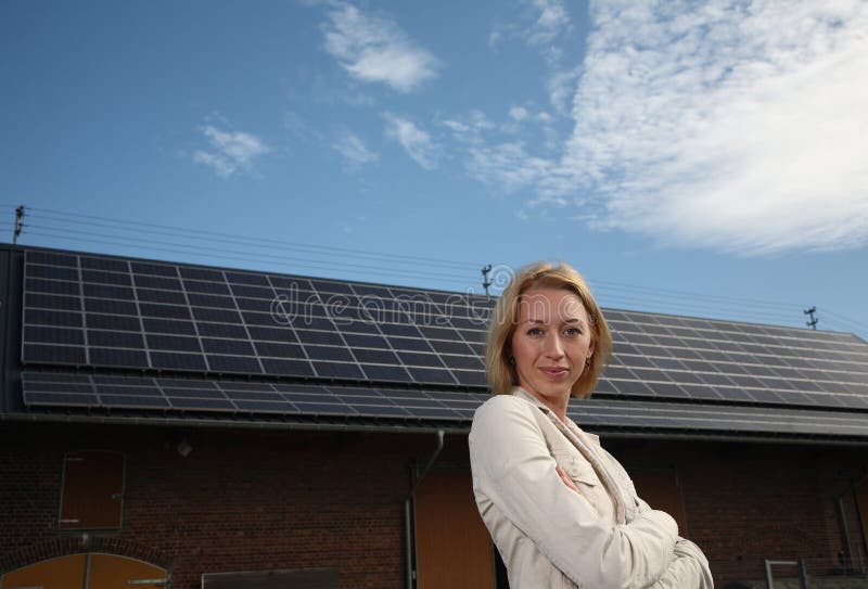 Young woman in front of solar-powered house