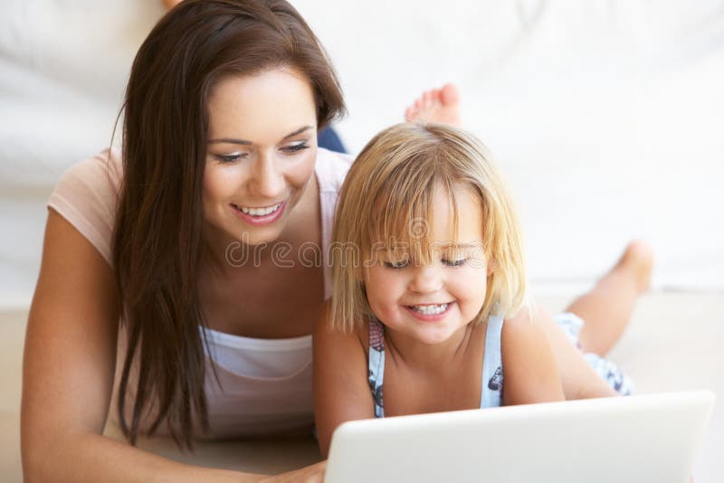 Young woman with girl using laptop computer at home. Laptop personal computer stock images, royalty-free photos and pictures