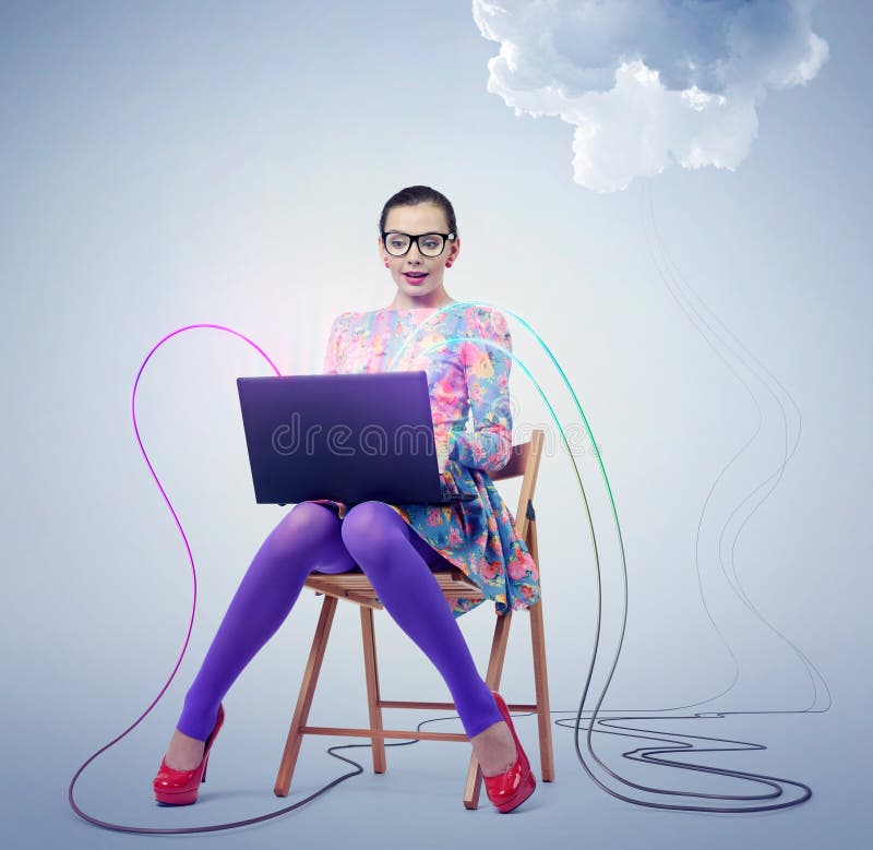 Young woman in glasses sitting on a chair with a laptop. Concept cloud computing. royalty free stock photos Young woman in glasses sitting on a chair with a laptop. Concept cloud computing. royalty free stock photos