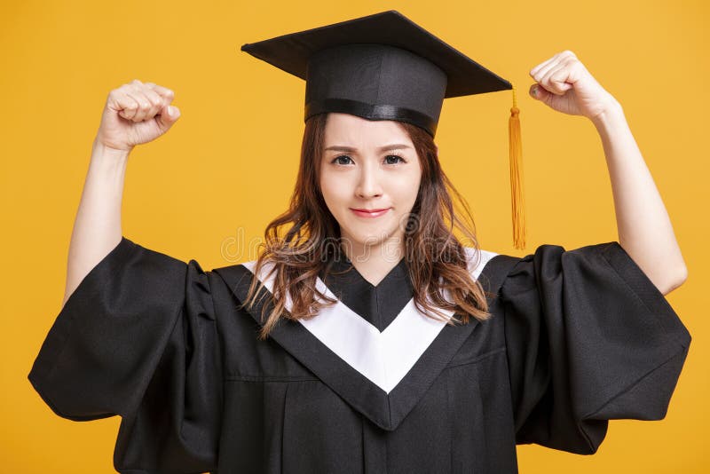 Young woman in graduation gowns and showing success gesture royalty free stock image Young woman in graduation gowns and showing success gesture royalty free stock image