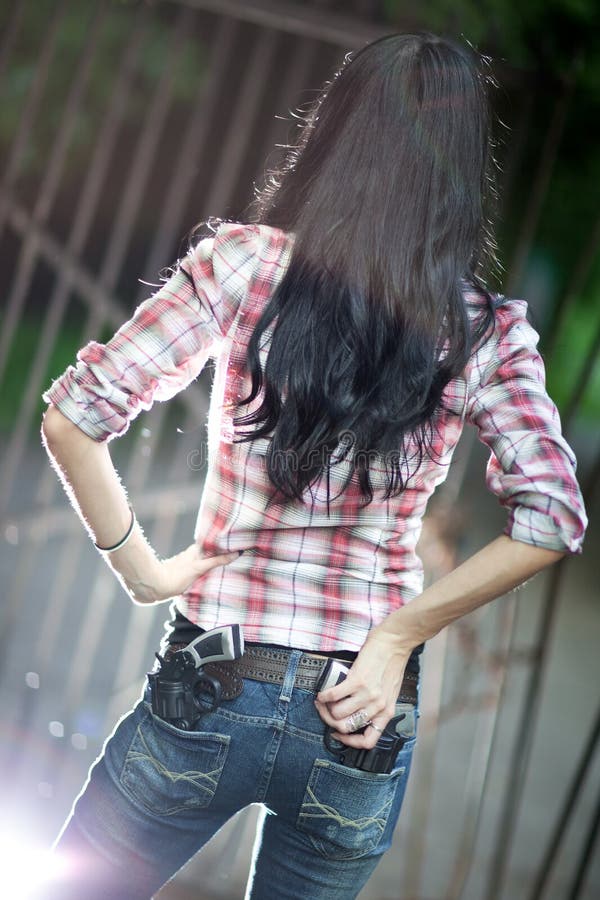 Young woman with guns backside view royalty free stock photo
