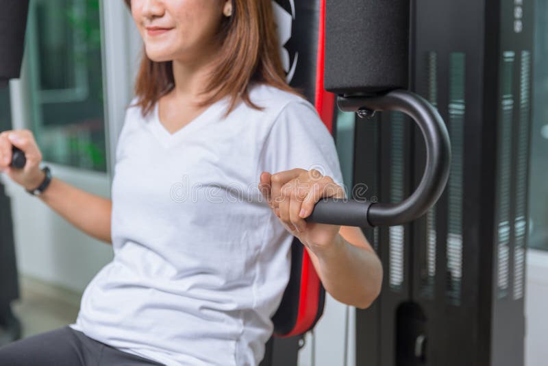 Young woman in the gym training chest muscle royalty free stock images Young woman in the gym training chest muscle royalty free stock images