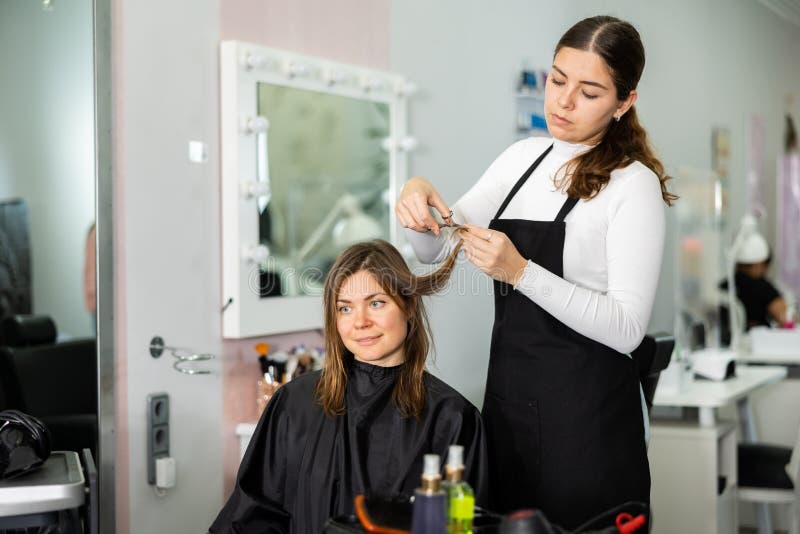 Young Woman Hair Stylist Making Haircut To Female Client Stock Image ...