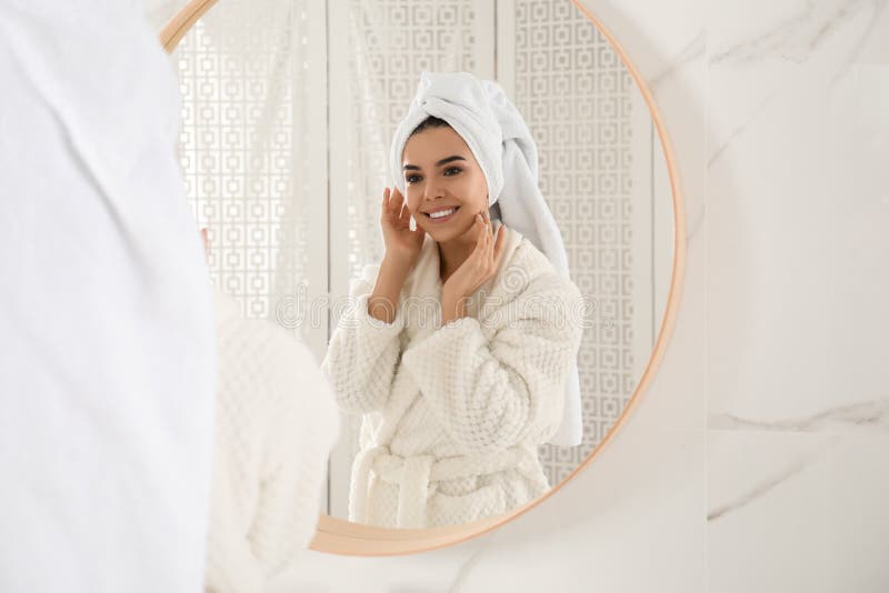 Young woman with hair wrapped in towel near mirror stock image Young woman with hair wrapped in towel near mirror stock image