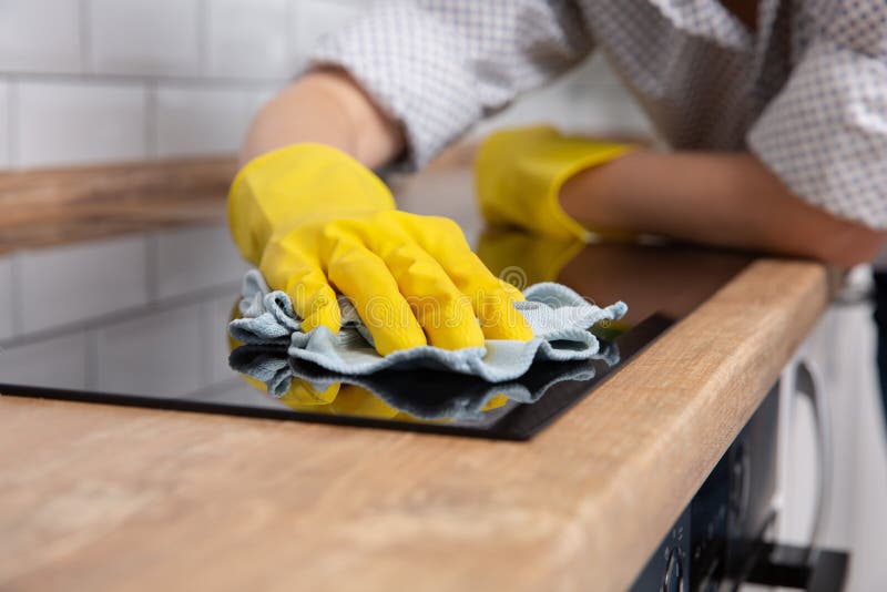 Young woman hands cleaning a modern black induction hob by a rag, housework stock images Young woman hands cleaning a modern black induction hob by a rag, housework stock images