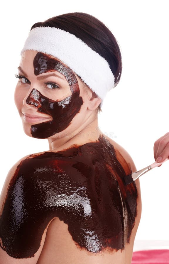 Young woman having chocolate facial mask.