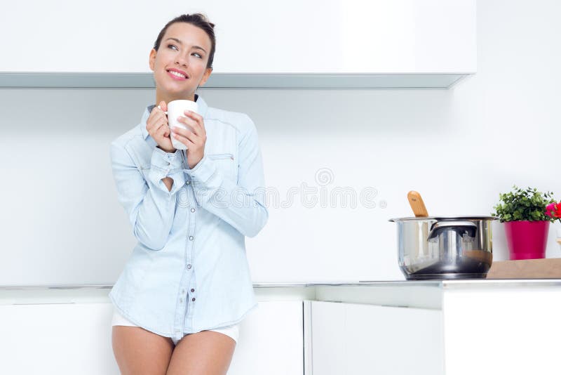 Young woman having a coffee at the kitchen