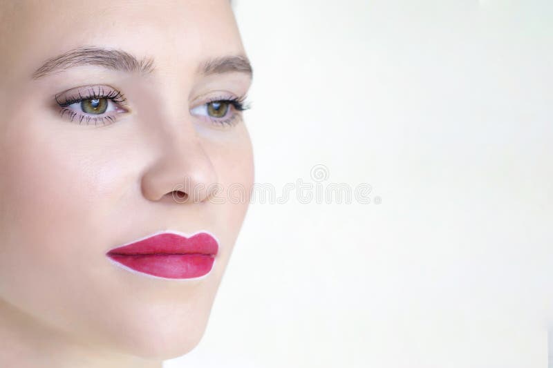 Young woman having permanent makeup on her lips at the beauticians salon