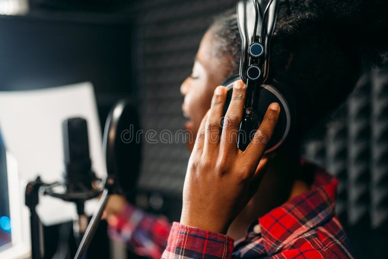 Young woman songs in audio recording studio stock photo Young woman songs in audio recording studio stock photo