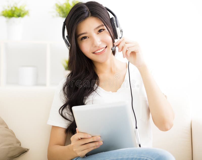 Young Woman with headphones and tablet in living room