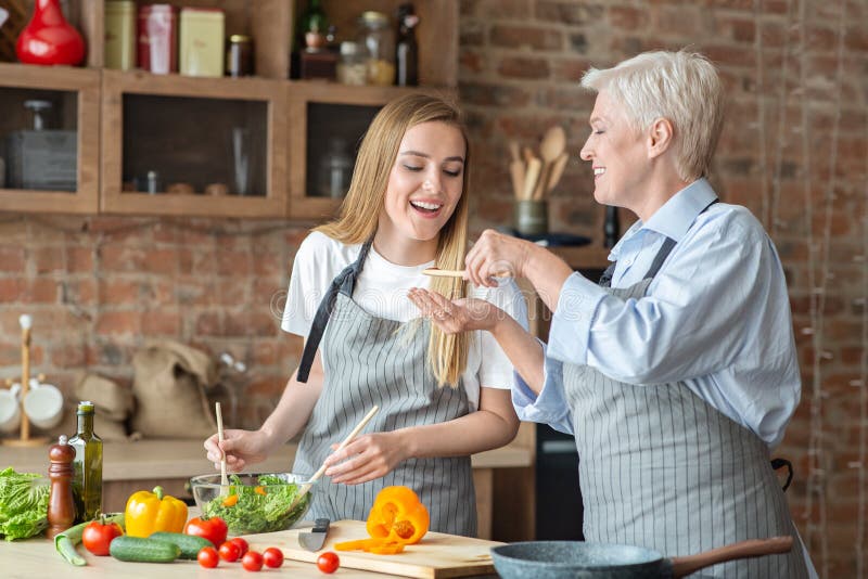 Young Woman Helping Her Old Mother with Dinner Stock Image - Image of ...