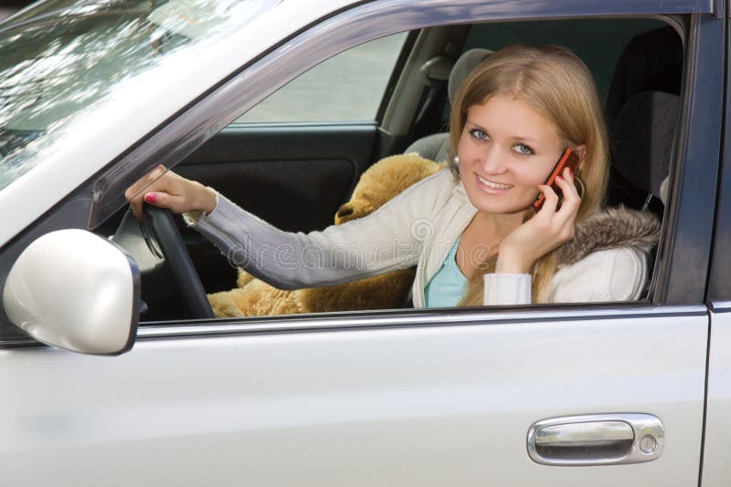 Young woman in her car while on the cell phone