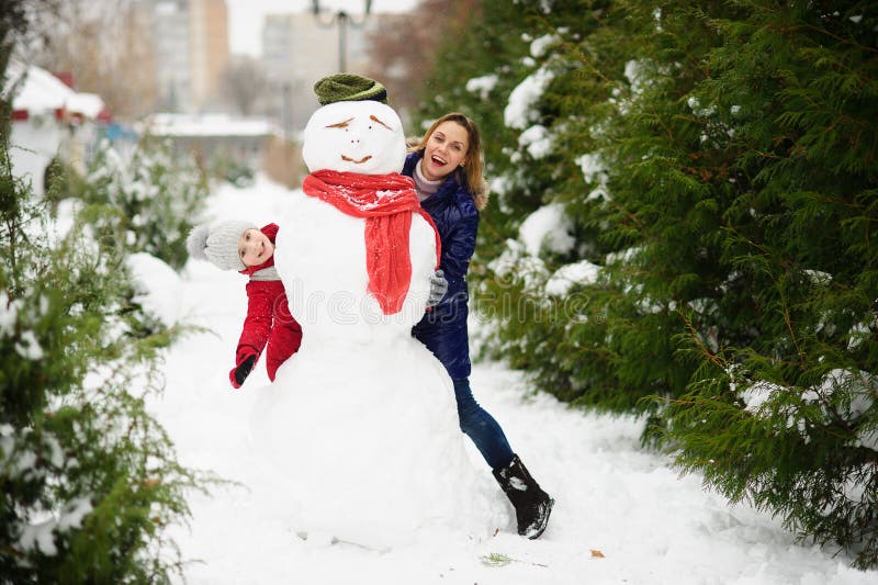 The young woman and her daughter look out because of a big snowman