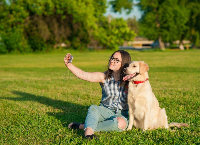 Young woman and her friendly dog taking a selfie at a park royalty free stock photo Young woman and her friendly dog taking a selfie at a park royalty free stock photo