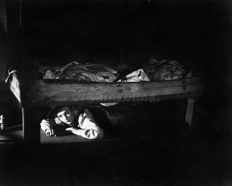 Young woman hiding under the bed