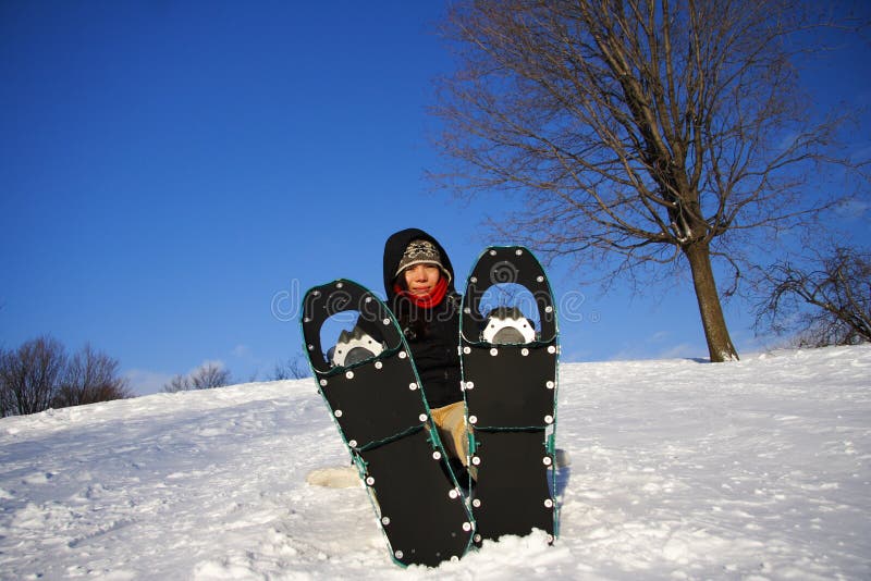 Young woman taking a hiking break with snowshoes in Quebec, Canada. Young woman taking a hiking break with snowshoes in Quebec, Canada