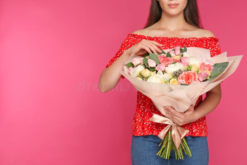 Young woman holding beautiful flower bouquet on pink background, closeup stock photography Young woman holding beautiful flower bouquet on pink background, closeup stock photography