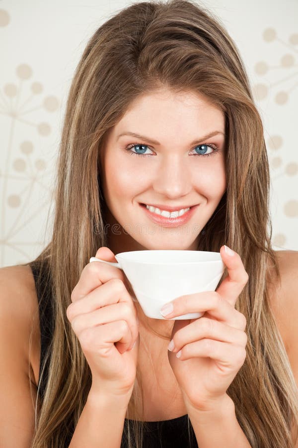 Young woman holding a cup of tea and smiling