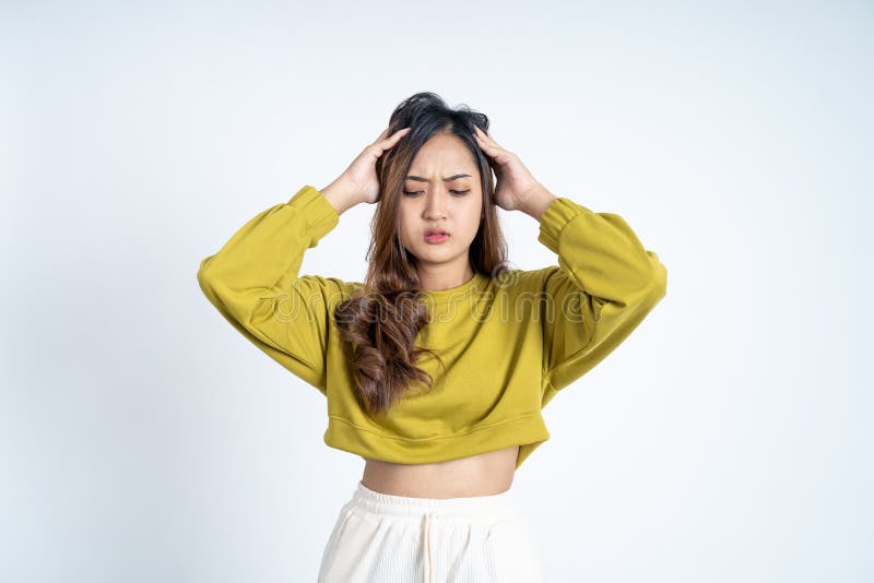 Young woman holding head while confused by situation on  background