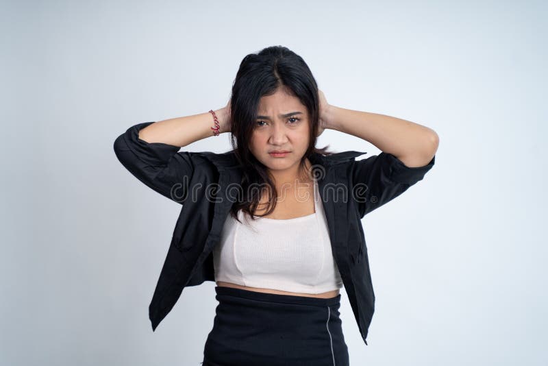 Young woman holding head while confused by situation on isolated background