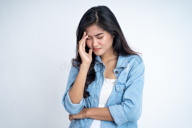 Young woman holding head while confused by situation on isolated background