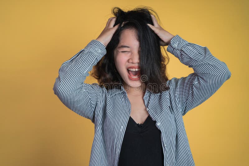 Young woman holding head while confused by situation on isolated background