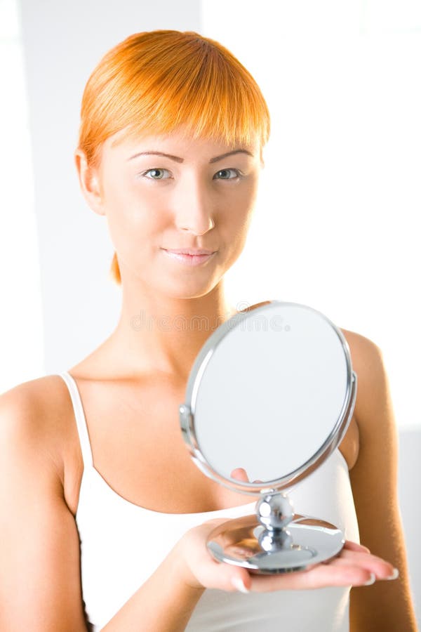 Young woman holding mirror