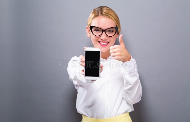 Young woman holding out a cellphone royalty free stock images