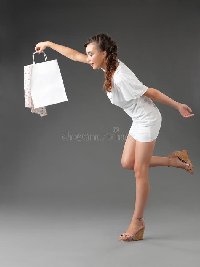 Young woman holding shoppping bag, tumbling