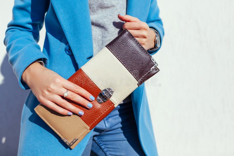 Young Woman Holding Stylish Handbag and Wearing Trendy Blue Coat ...