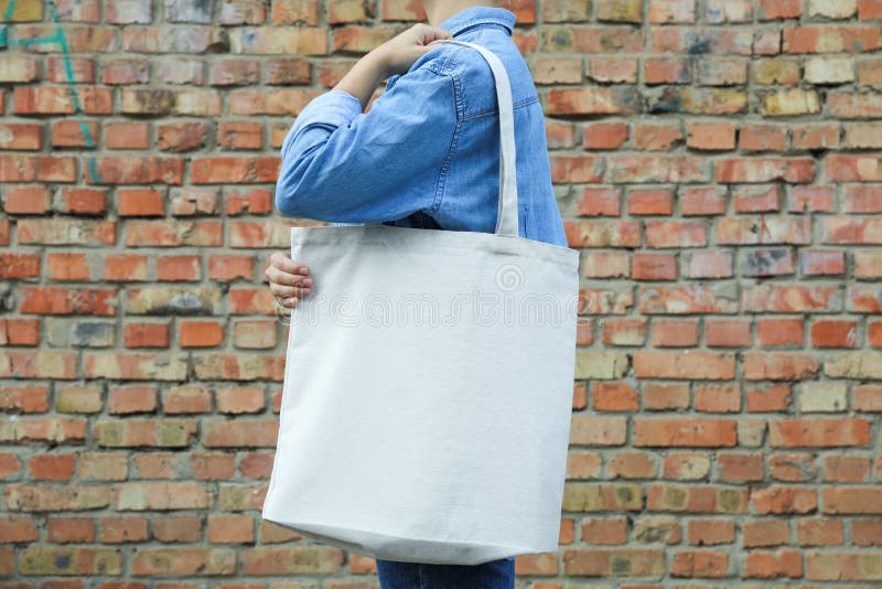 Young Woman Holding Tote Bag Against Brick Wall Empty 