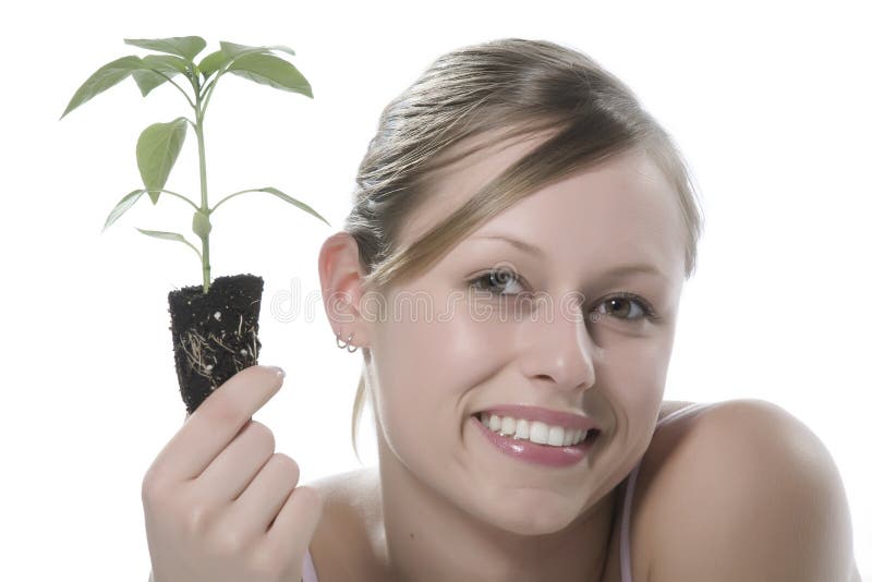 Young woman holding young sprout in the hands.