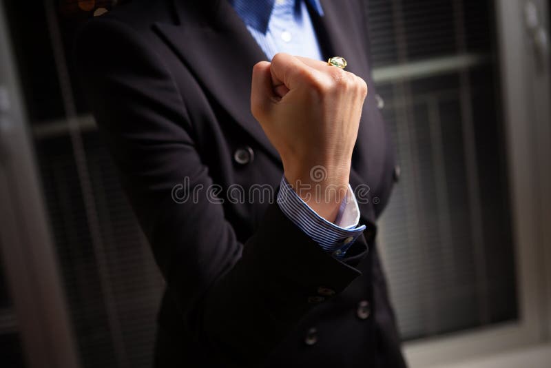 A young woman holds her fist high